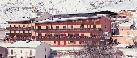 A multi-story hotel with balconies, a restaurant, and a sign indicating a restaurant.