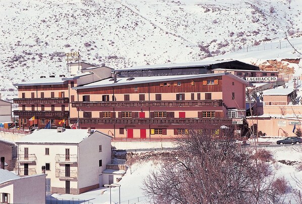 A multi-story hotel with balconies, a restaurant, and a sign indicating a restaurant.