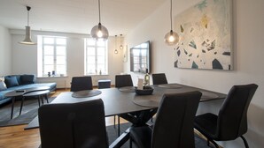 Una sala de reuniones moderna con una larga mesa, sillas negras e iluminación colgante.