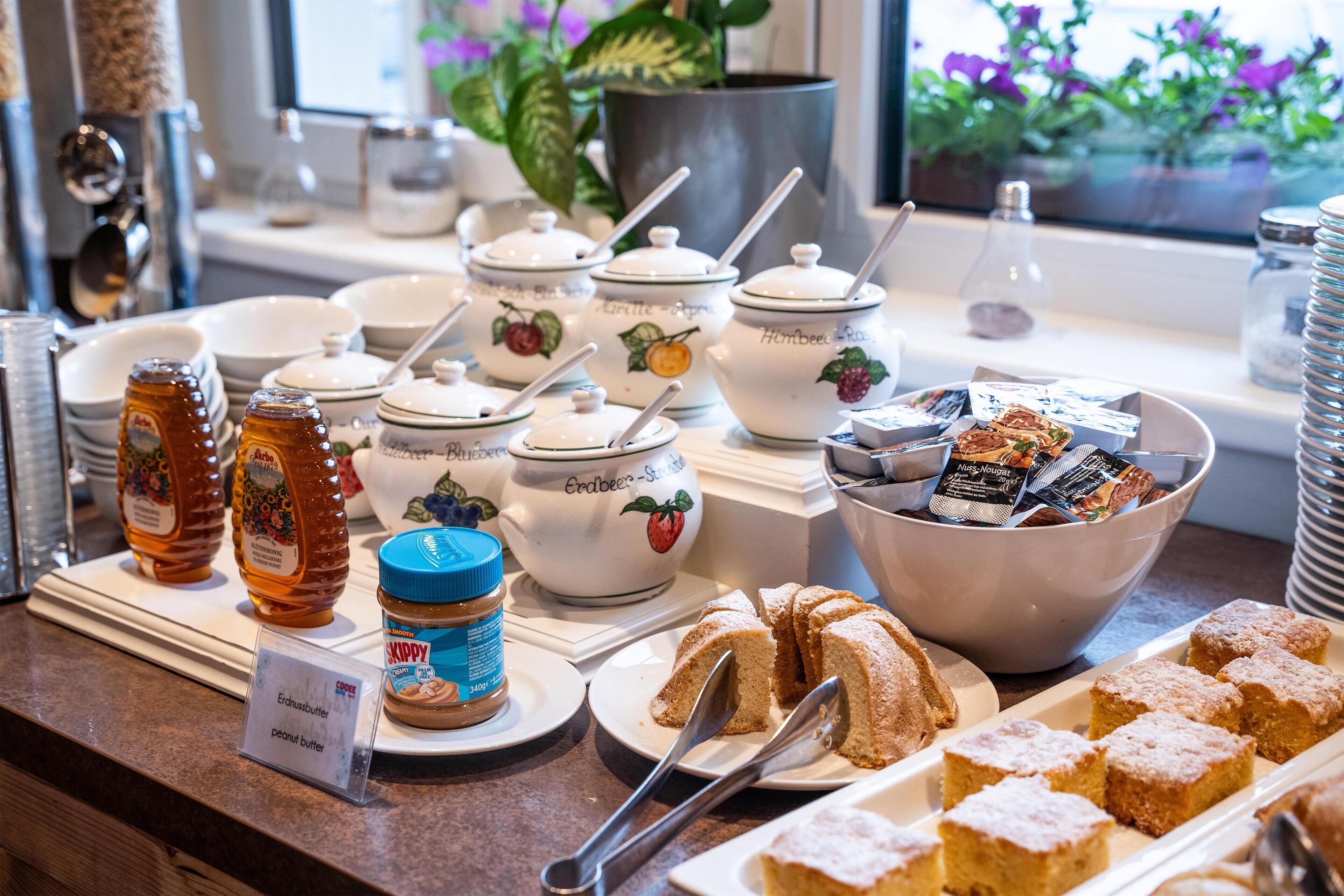 A buffet setup with various food items and condiments.