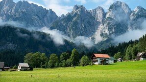 Un paisaje montañoso con un pueblo y casas al frente.