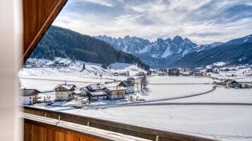 A snowy mountain landscape with a village and houses.