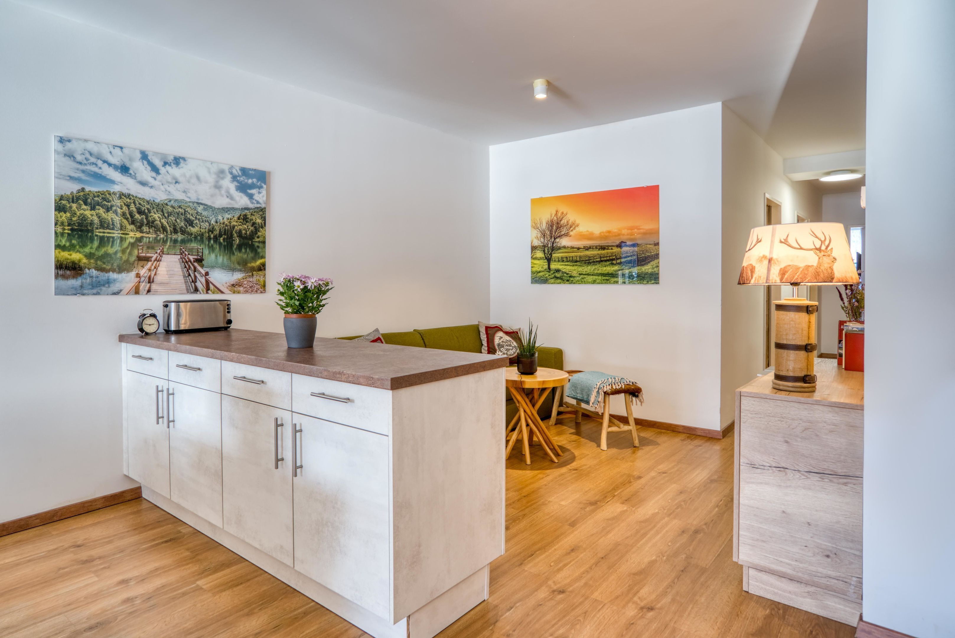 Una cocina moderna con encimera de madera, zona de comedor con mesa y sillas, y un sofá.