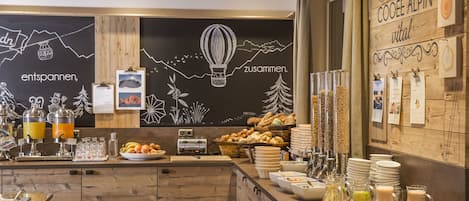 A breakfast buffet area with various food items and beverages.