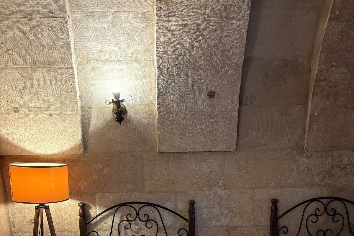 Habitació d'hotel amb dos llits, una taula petita, una làmpada i una làmpada de paret.