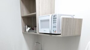 A compact kitchen with a microwave, sink, and dishwasher.
