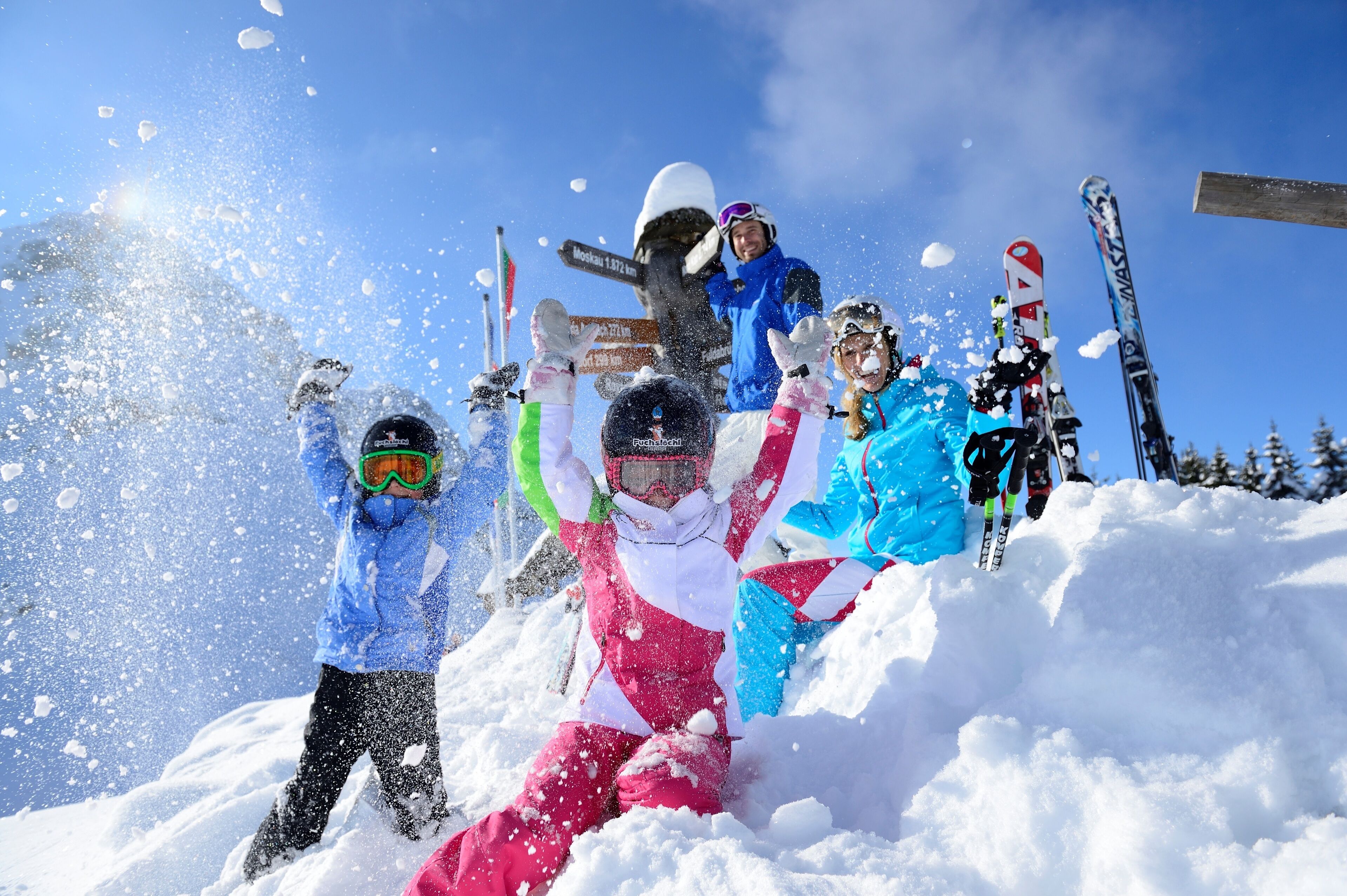 Un groupe de personnes qui célèbrent dans la neige, dans une région montagneuse.