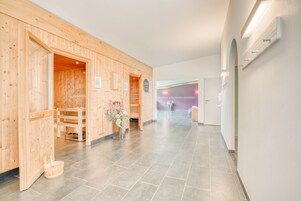 A wooden interior hallway with a wooden bench and a small table with flowers.