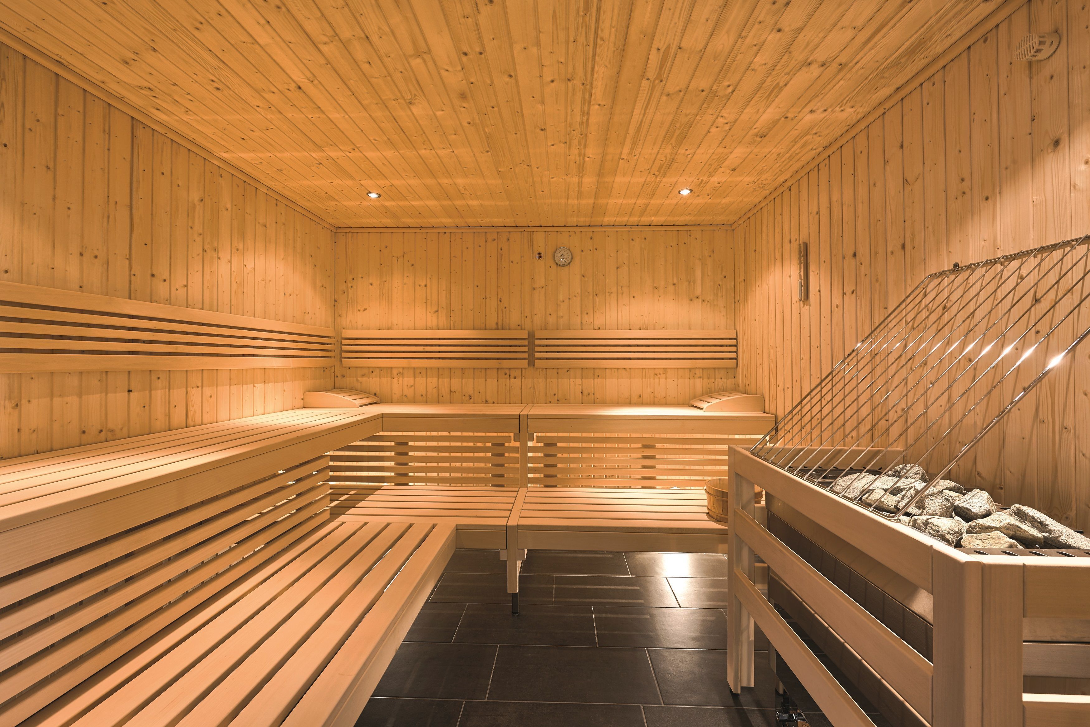 A sauna with wooden benches and a stone bench.