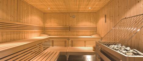 A sauna with wooden benches and a stone bench.