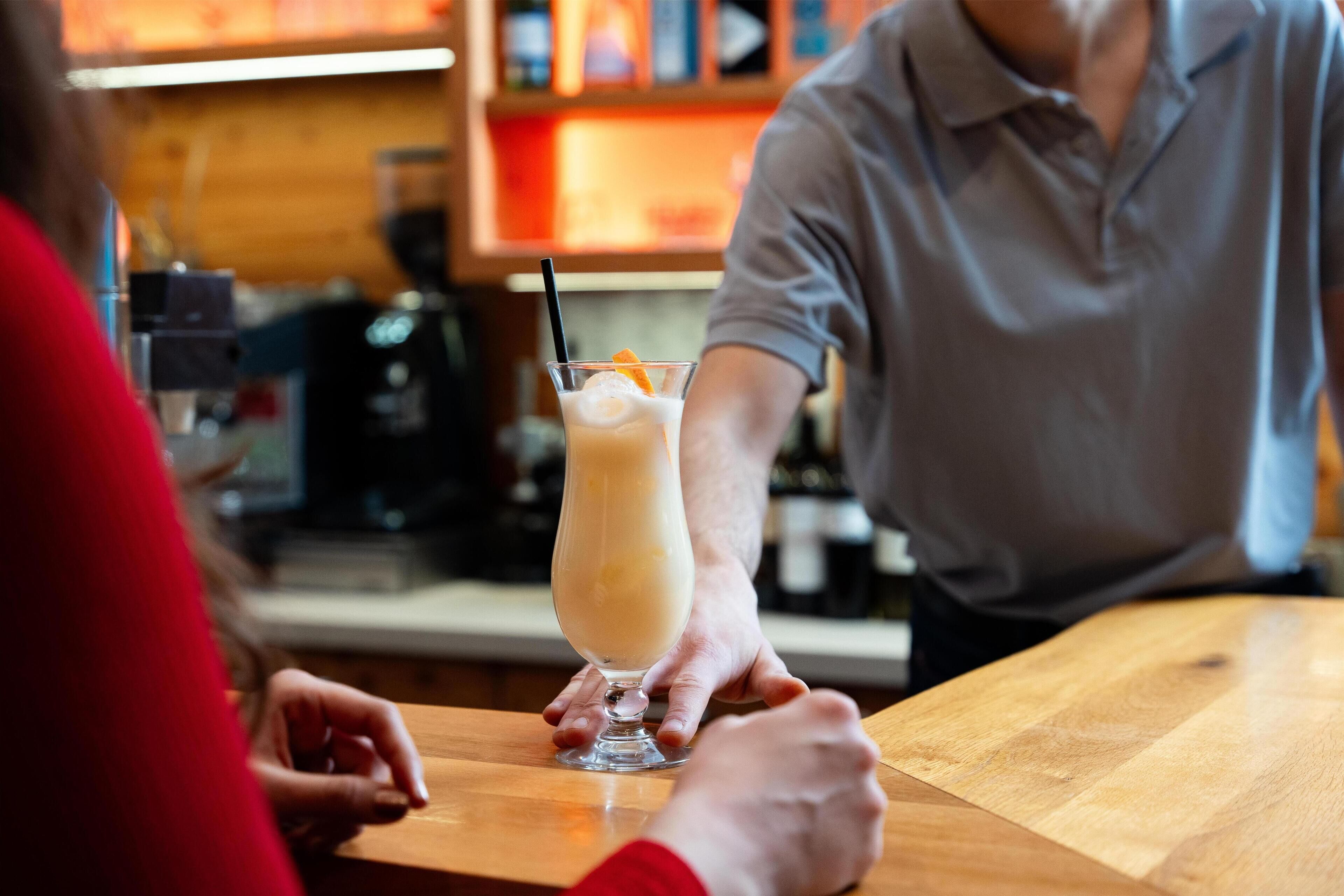 A bar setting with a person holding a drink.