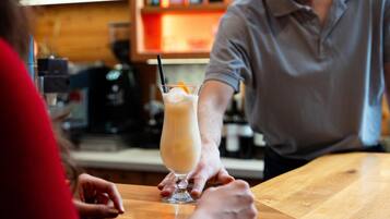 A bar setting with a person holding a drink.