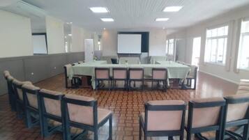 Une salle de conférence équipée d’une longue table, de chaises et d’un écran de projection.