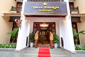 The entrance of Hanoi Nostalgia Hotel & Spa with a red carpet leading up to the doors.