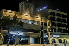 Un hotel con un cartel que dice "Modena Hotel" y un edificio con un letrero que indica "Best Arts".