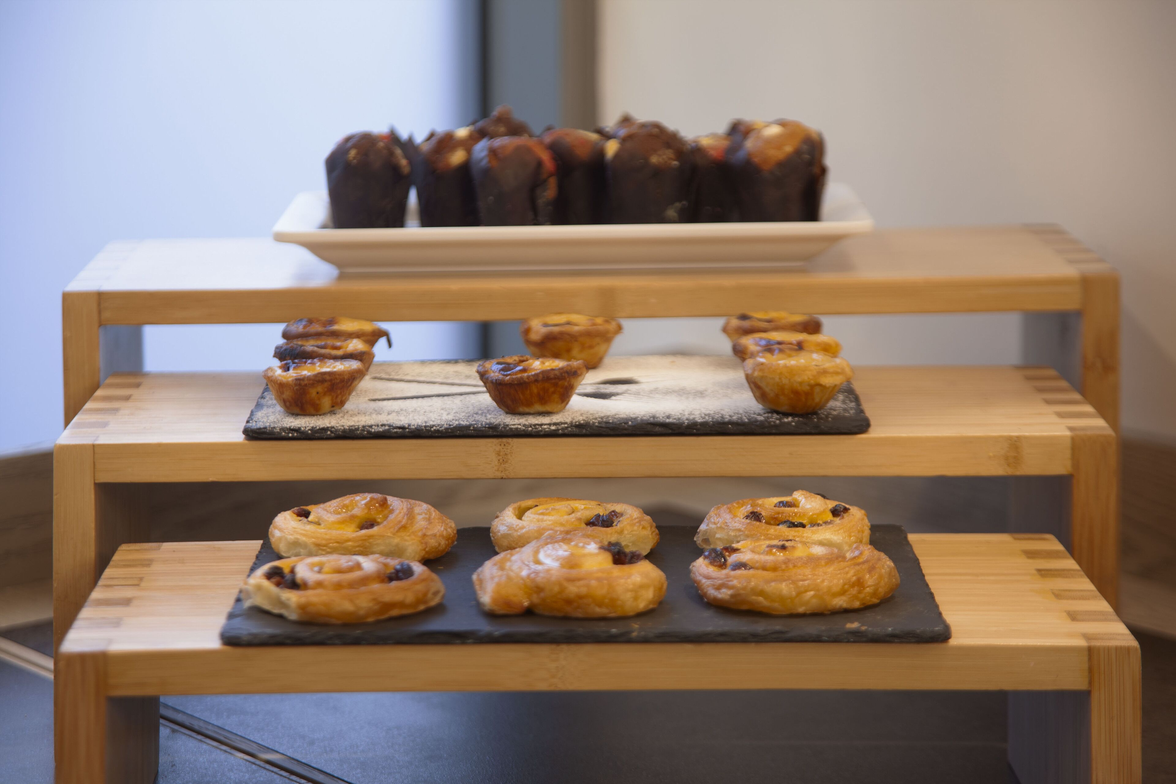 A display of pastries on a wooden stand.