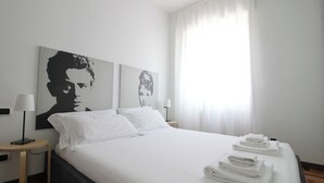 A hotel room with a large bed, two bedside tables with lamps, and a window with sheer curtains. - Italianway   - Lodi 78 (Milan)