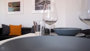 Une table à manger avec un saladier bleu, un verre à vin et un verre à eau.