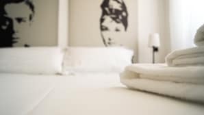 A neatly made bed with a folded white towel on the right side. - Italianway   - Lodi 78 (Milan)