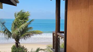 A balcony with a view of the beach and ocean.