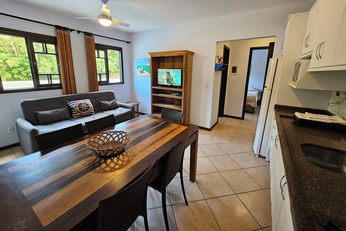 Ein modernes Wohnzimmer mit einer Couch, einem Holzesstisch und einem Fernseher.