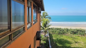 A building with large windows overlooking a beach. - Pousada Pedra da Gaivota (Bombinhas)