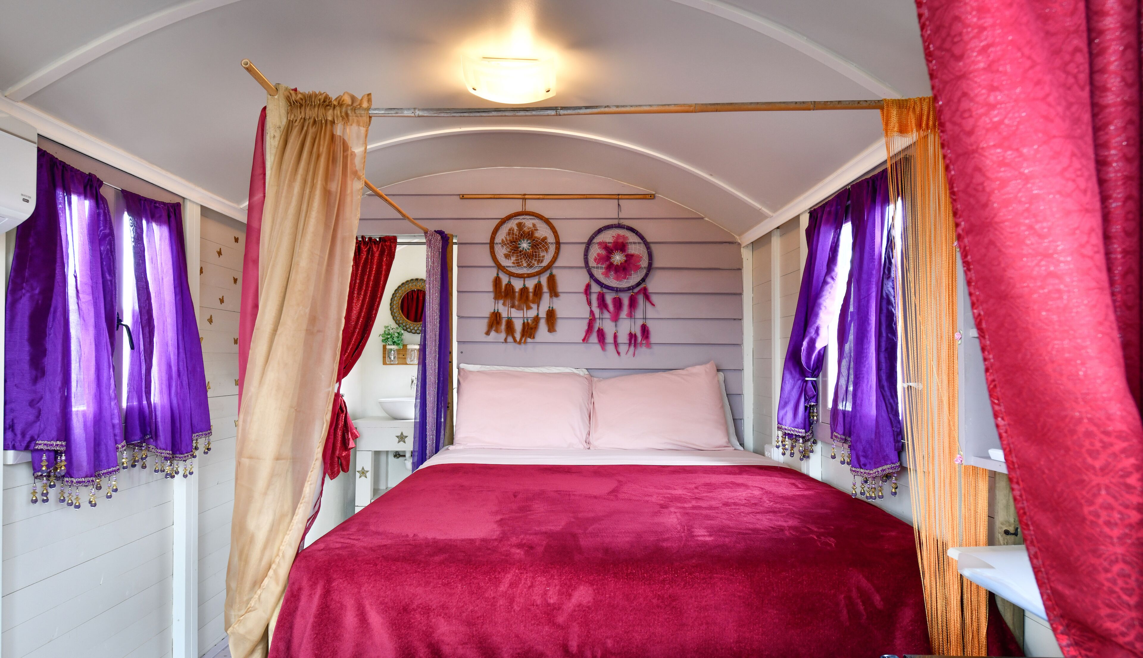 Ein Schlafzimmer mit Bett, Vorhängen und Wanddekorationen.