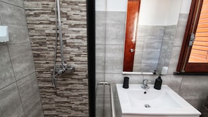 A bathroom with a shower, a sink, and a mirror. - Urban Beach I (Portimão)