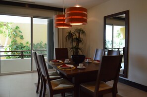 A dining area with a large table, chairs, a bowl, and a potted plant.