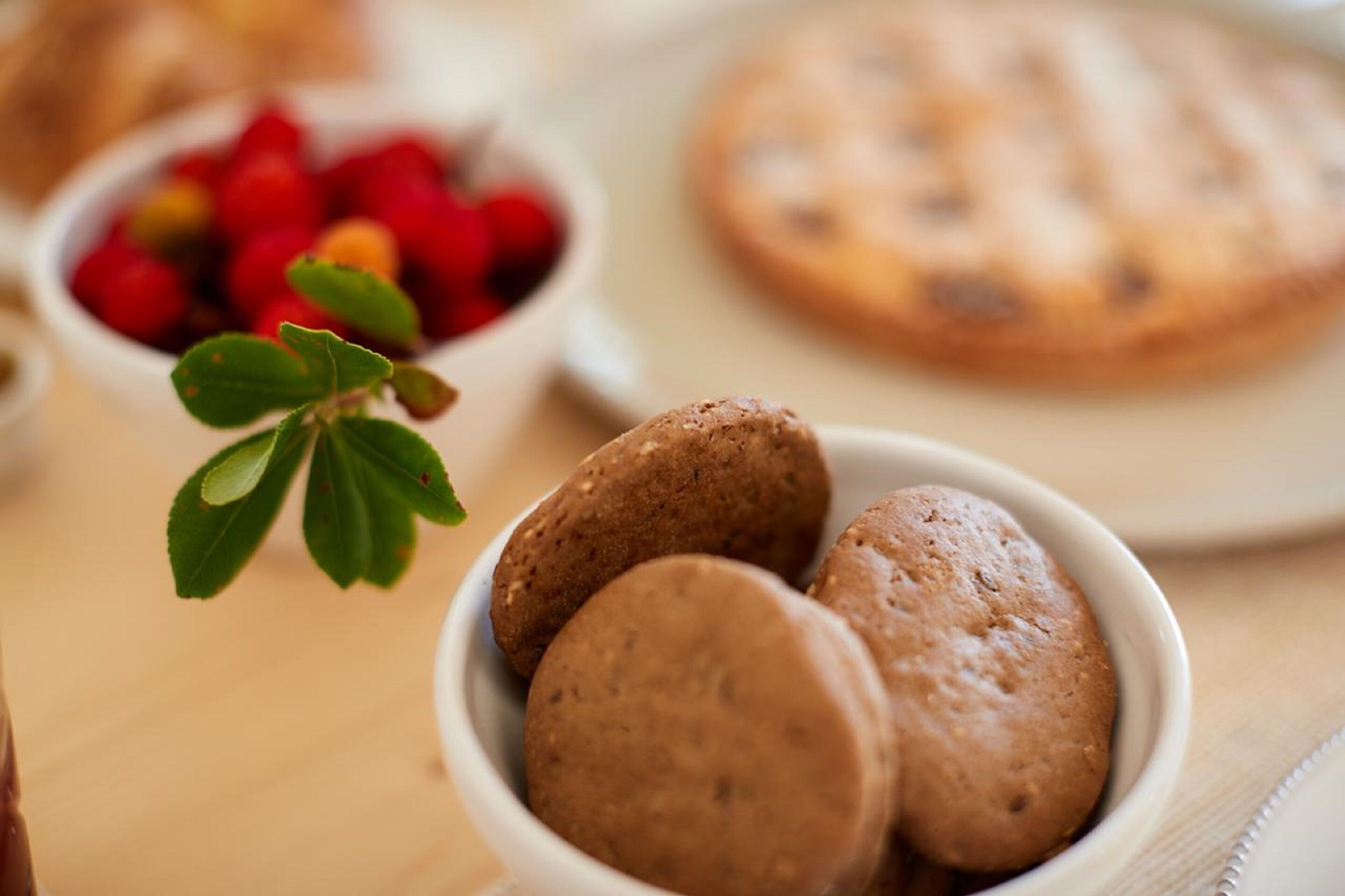 Un bol rempli de biscuits et une assiette de biscuits sur une table.