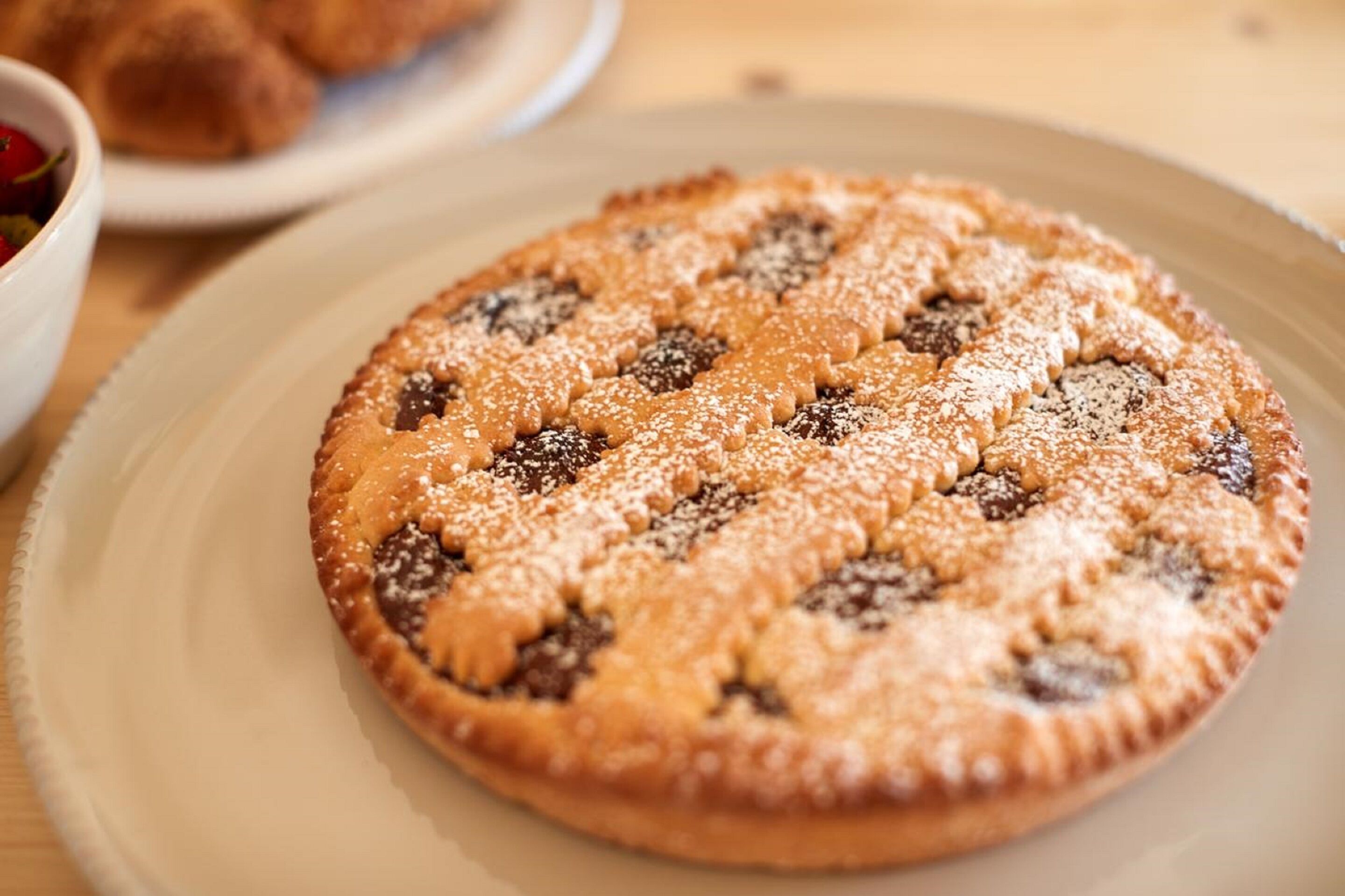 A round pie with a lattice crust on a plate.