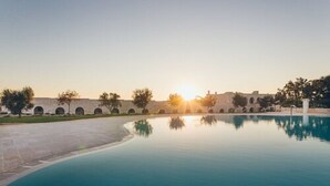 Una piscina con vistas despejadas a un edificio con arcos al fondo.