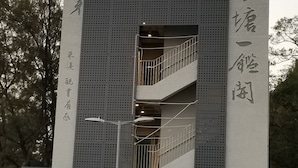 A building with large Chinese characters on its facade, a staircase, and a parking area with numerous bicycles. - Man Lai Wah Resort (Lamma Island)
