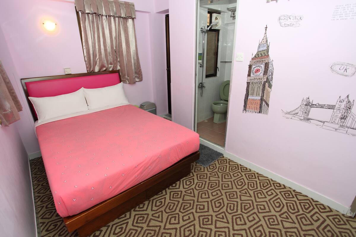 Un dormitorio con edredón rosa, alfombra estampada y pared con un dibujo del Big Ben y la London Eye.