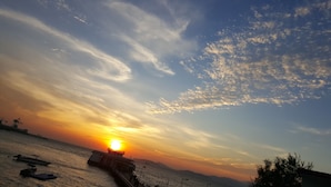 A sunset over a body of water with boats and a pier. - Man Lai Wah Resort (Lamma Island)