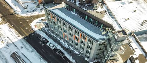 An aerial view of a multi-story building with a parking lot in front.