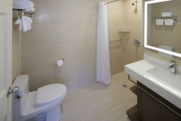 Un baño moderno con inodoro, ducha y lavamanos.