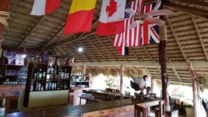 A bar area with flags of Belgium, Canada, and the USA hanging from the ceiling.