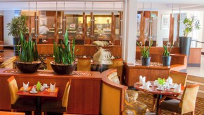 A modern hotel lobby with seating areas, potted plants, and a reception desk. - City Lodge Hotel Durban (Durban)