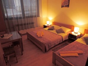 Quarto de hotel com cama, escrivaninha e cadeira.