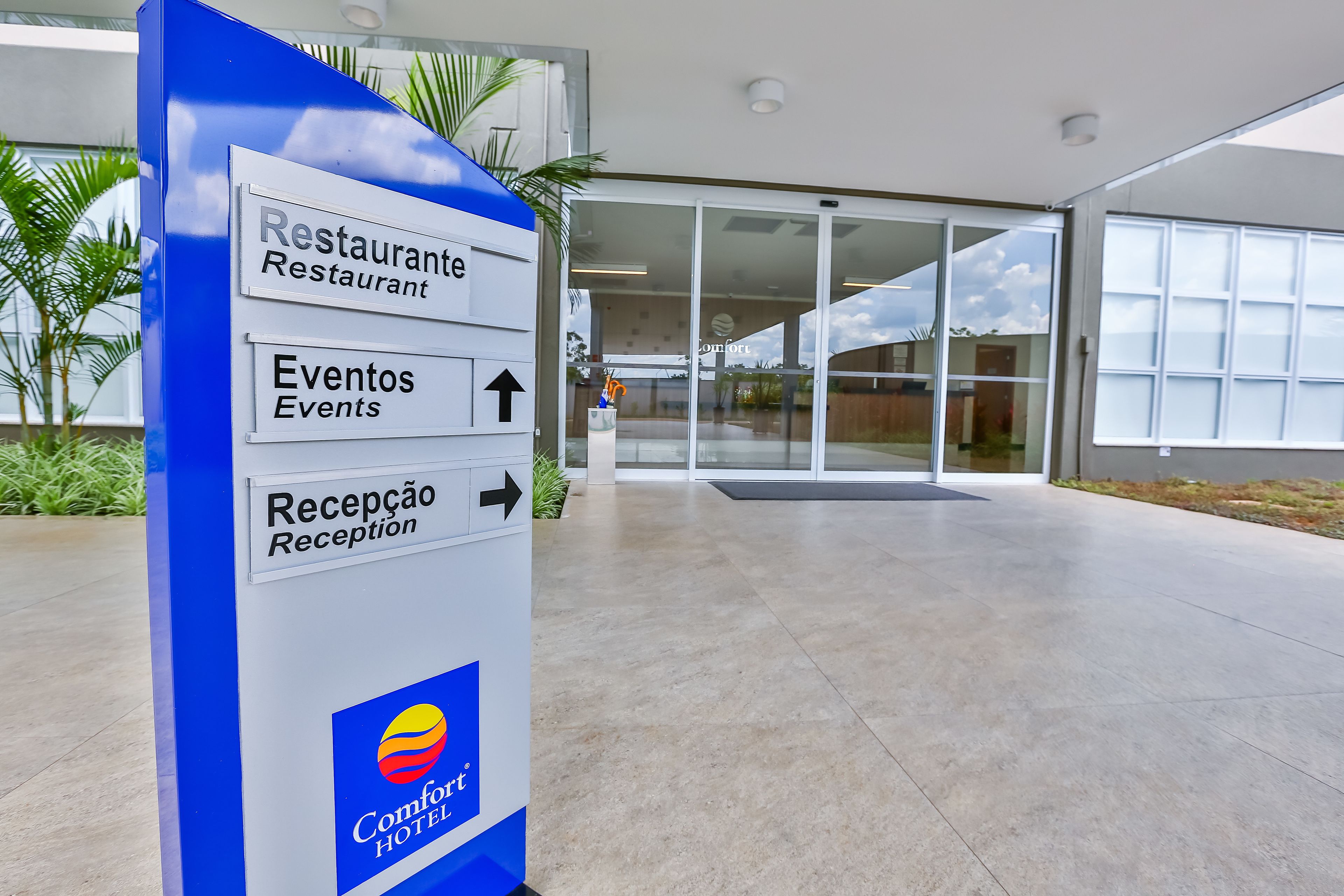 Zona de recepción de hotel con indicaciones hacia el restaurante, eventos y la recepción.