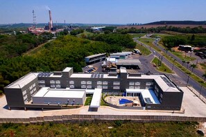 Uma grande instalação industrial com vários edifícios, estradas e áreas verdes.