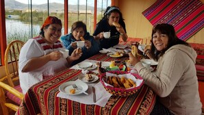 A group of people dining at a table with a view of a lake and mountains.
