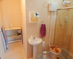 A bathroom with a toilet, sink, and shower. - Apartamento Alta Vista Gramado (Gramado)