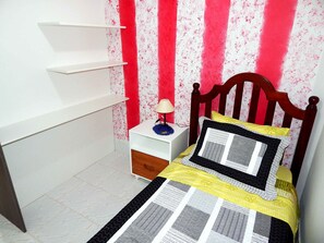 A bedroom with a wooden bed, a nightstand with a lamp, and a wall with a red and white pattern. - Apartamento Alta Vista Gramado (Gramado)