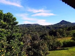 A view of a mountain range with lush greenery and a clear sky.