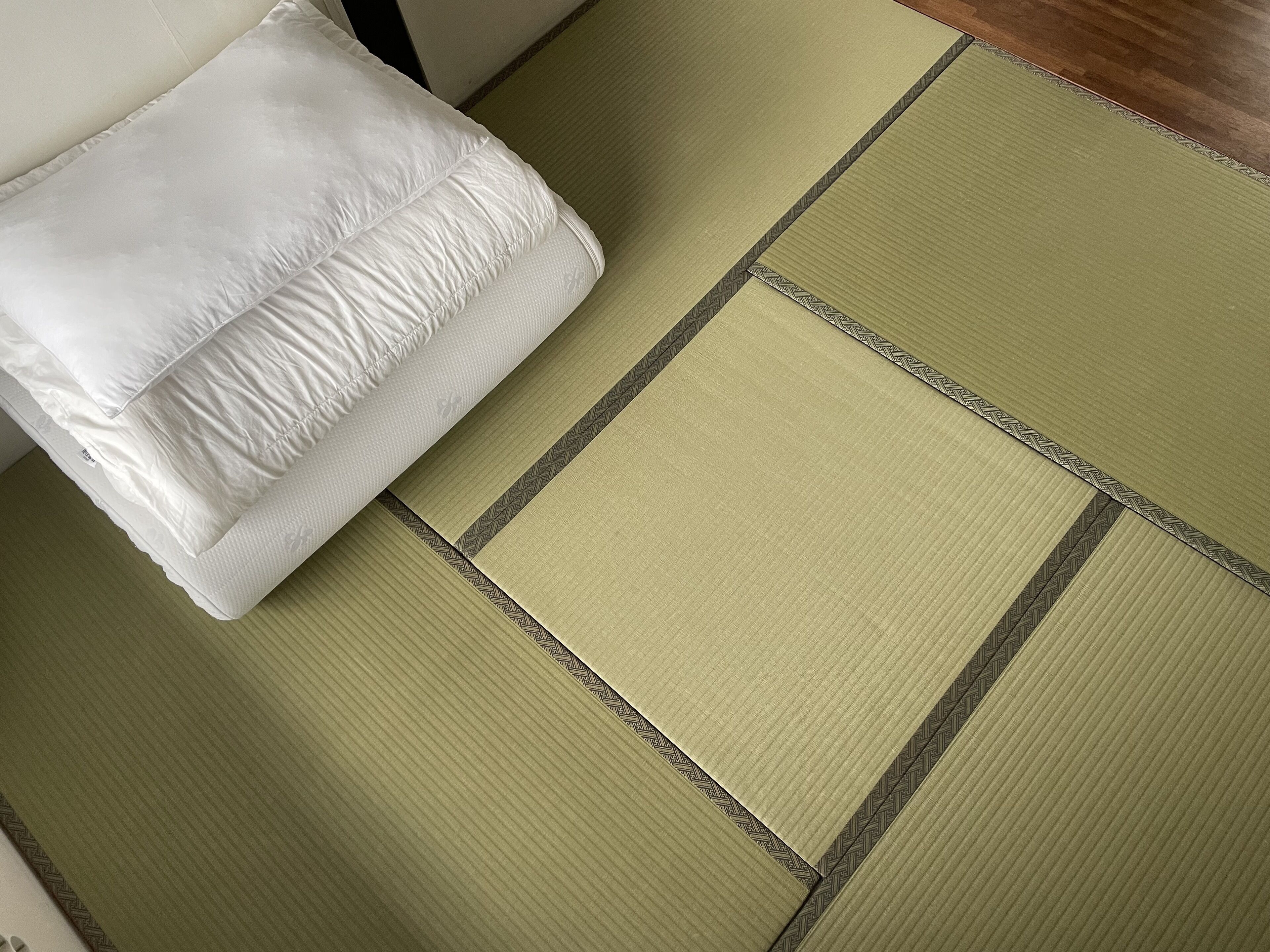 A tatami mat room with a white pillow.
