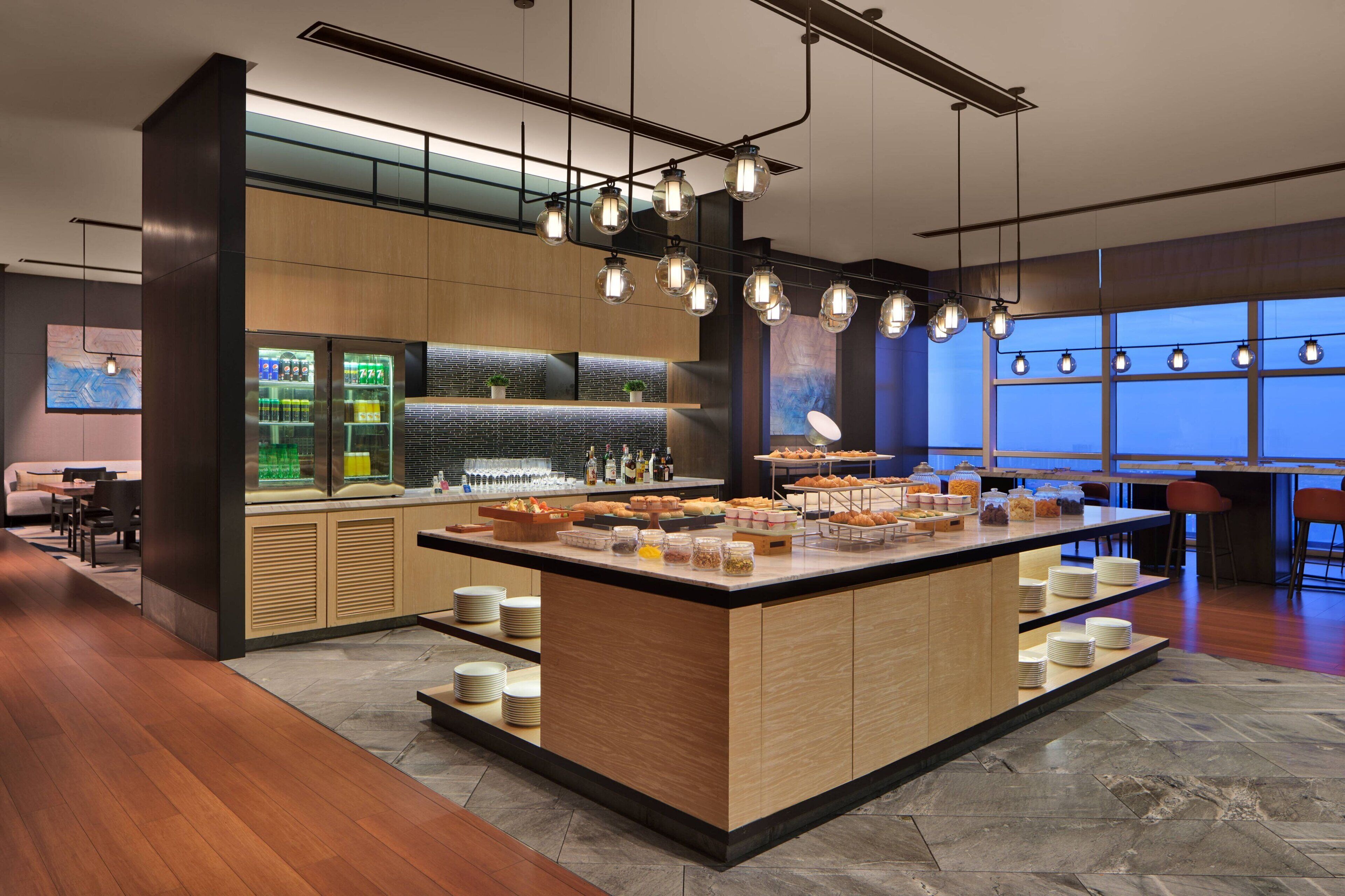 A modern kitchen area with a central island, bar area, and seating space.