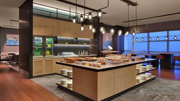 A modern kitchen area with a central island, bar area, and seating space.