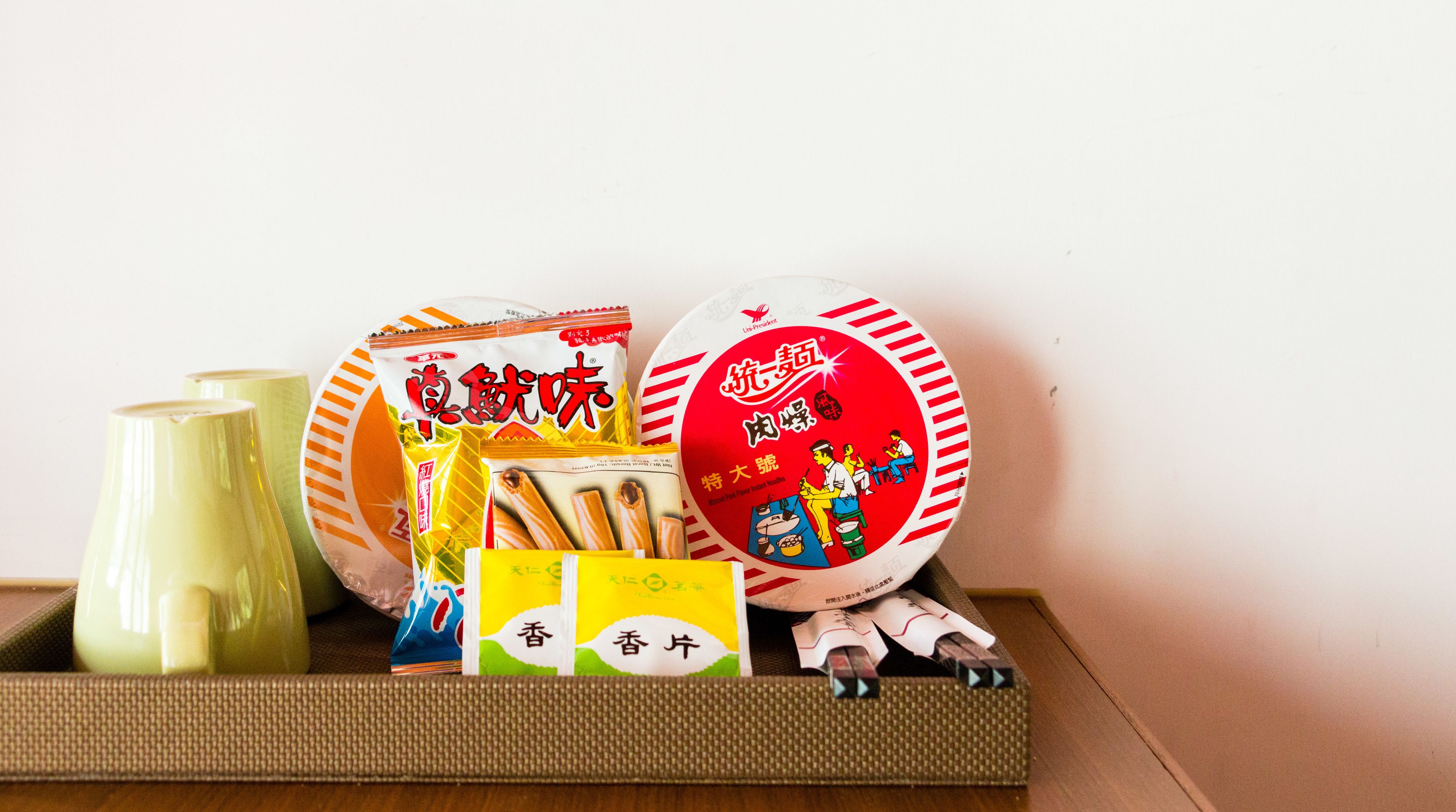 A tray with various food items including a green bottle, a yellow packet, and a red and white plate with illustrations.